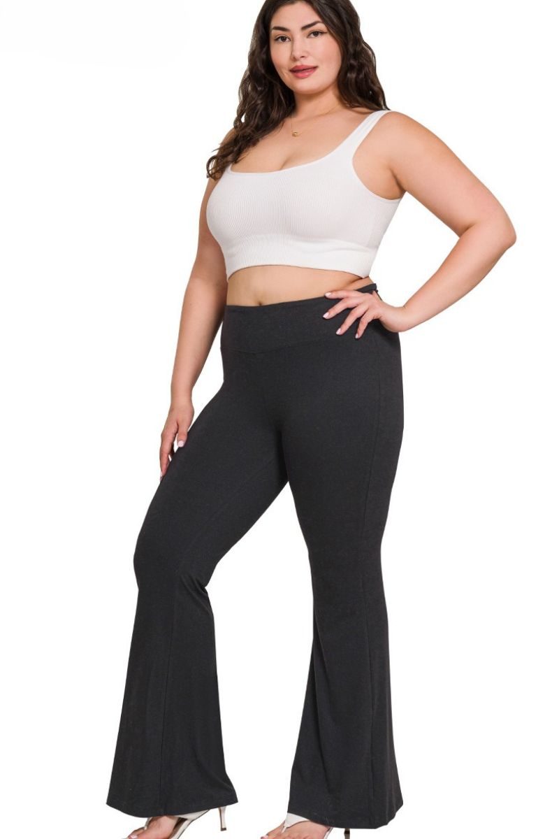 Woman wearing a white top and black flared pants on a white background