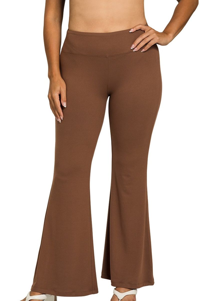 Brown flared pants worn by a person on a white background