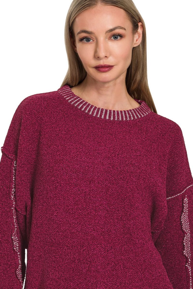 Woman wearing a maroon sweater with decorative trim on a white background