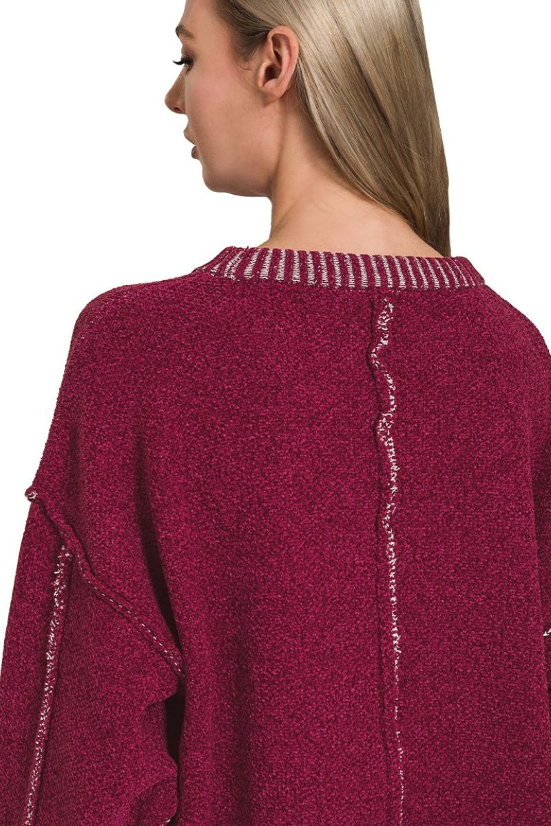 Close-up of a maroon sweater with white trim on a white background