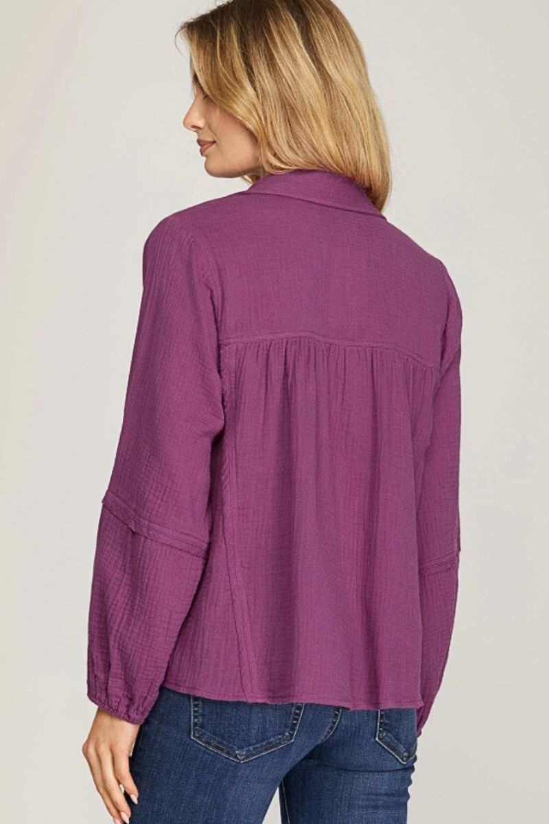 Woman wearing a purple shirt with a plain background