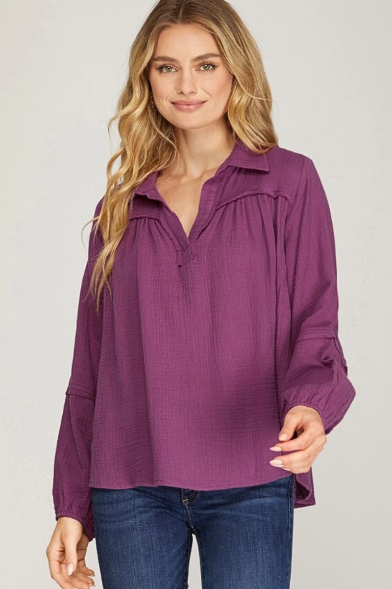 Woman wearing a purple blouse with a plain background