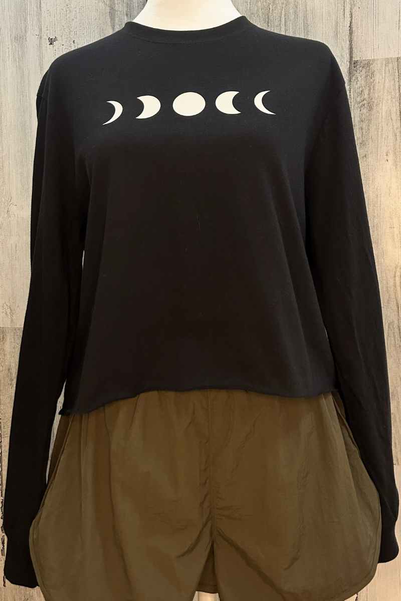 Sustainable long sleeve crop tee in classic black with a raw edge bottom and moon phase design