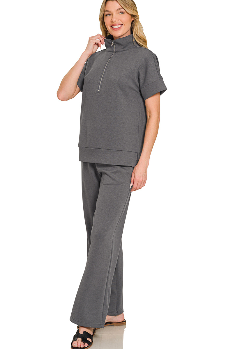 Woman wearing a gray outfit with a matching top and pants on a white background