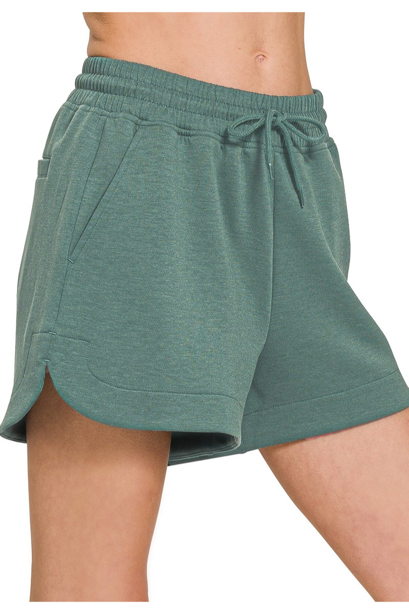 Green shorts worn by a person on a white background