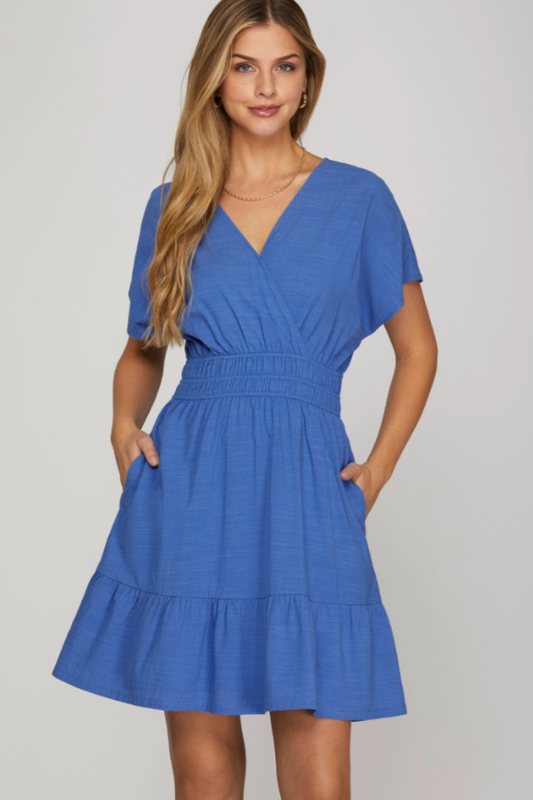 Woman wearing a blue dress against a plain background