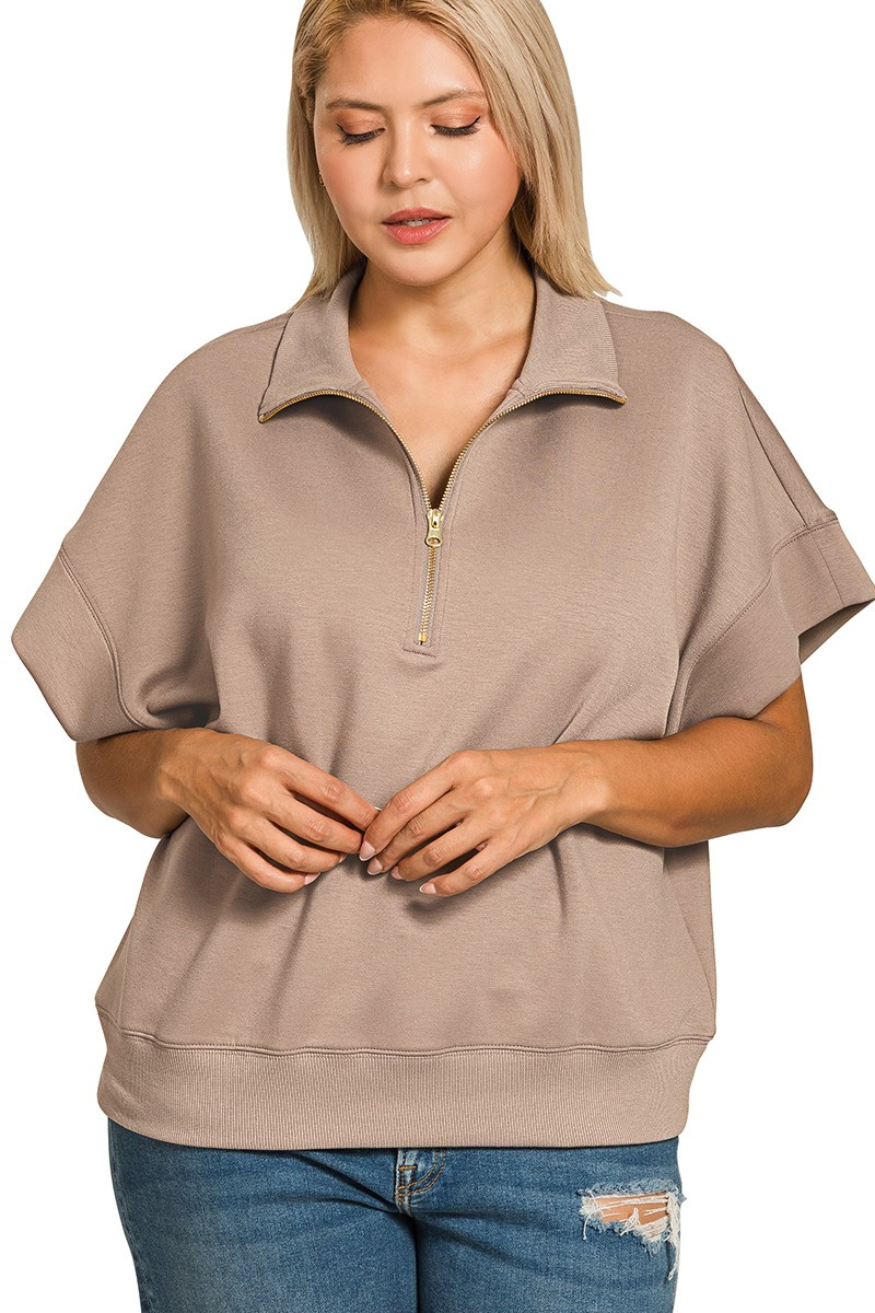 Woman wearing a beige short-sleeve pullover with a zipper on a white background