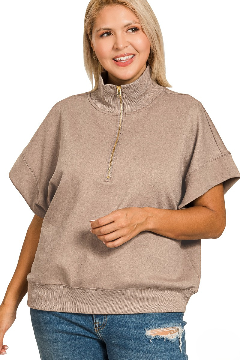Woman wearing a beige short-sleeve pullover with a zipper on a white background