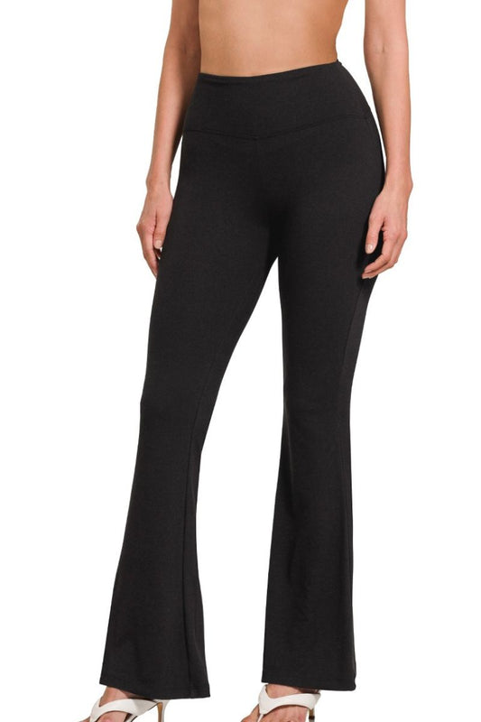 Black flared pants worn by a person on a white background