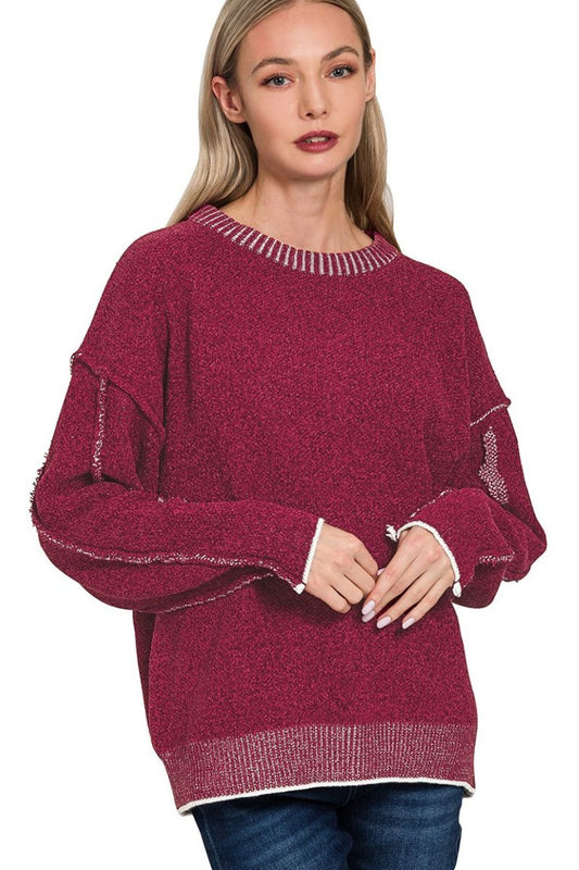 Woman wearing a burgundy sweater with white trim on a white background