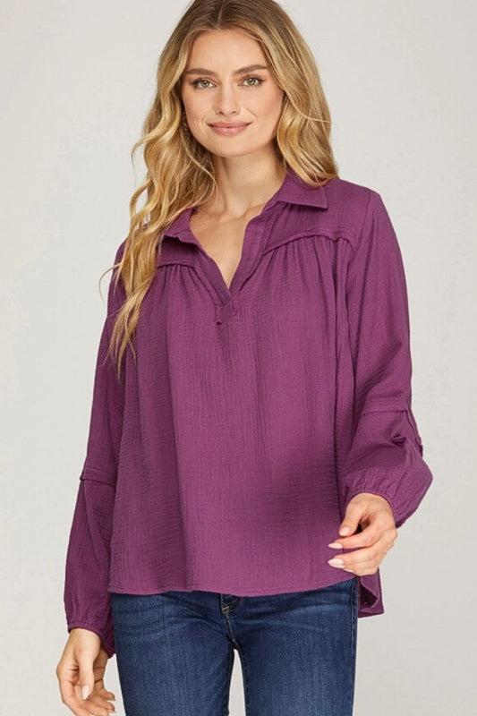 Woman wearing a purple blouse with a plain background