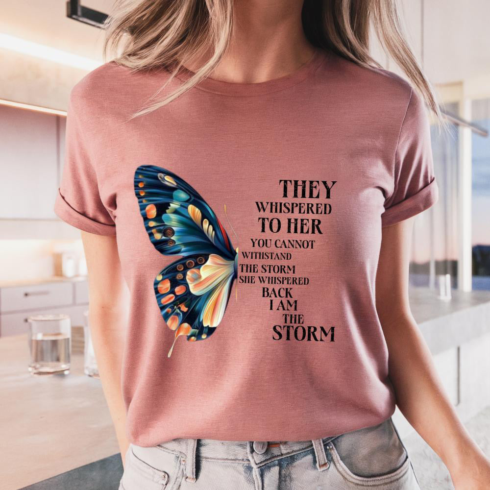 Person wearing a pink t-shirt with a butterfly graphic and motivational quote.
