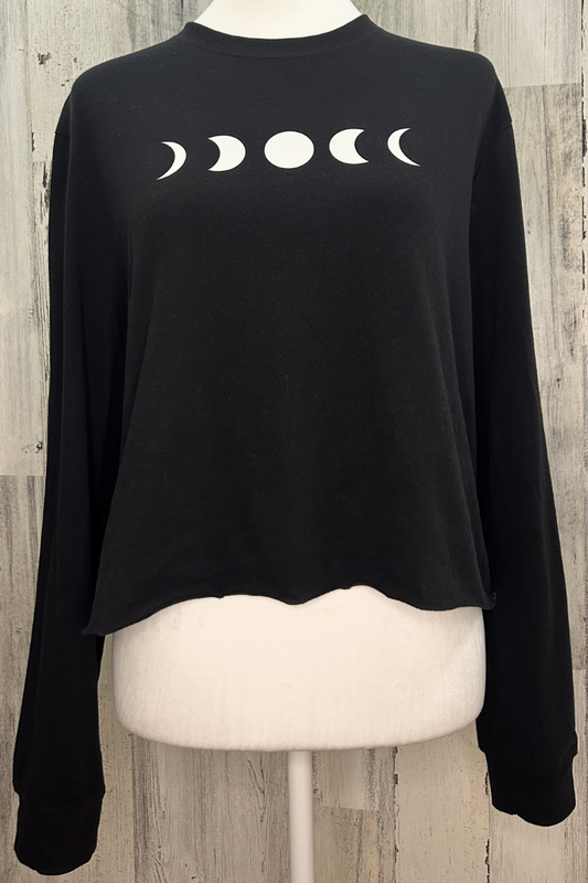 Sustainable long sleeve crop tee in classic black with a raw edge bottom and moon phase design