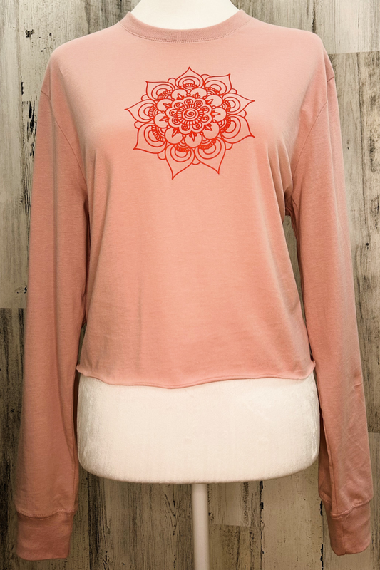 Sustainable long sleeve crop tee in pink with a raw edge bottom and mandala design