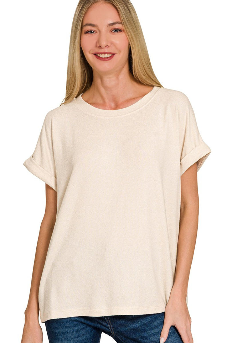 Woman wearing a beige t-shirt and blue jeans on a white background