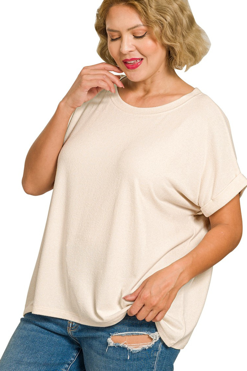 Woman wearing a beige oversized t-shirt and blue jeans on a white background