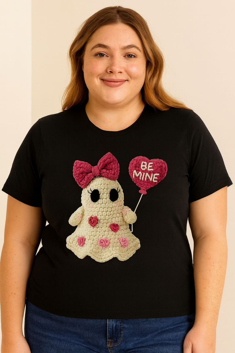 Person wearing a black t-shirt with a cartoon ghost design and 'Be Mine' balloon.